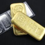 黒い背景に置かれた金のインゴットとパッケージ入りのプラチナ地金