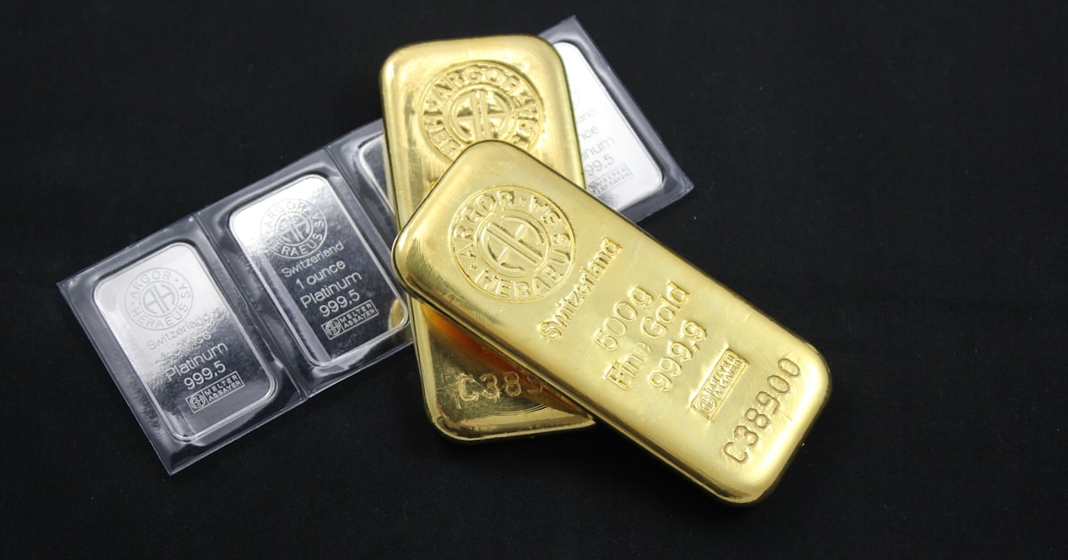 黒い背景に置かれた金のインゴットとパッケージ入りのプラチナ地金